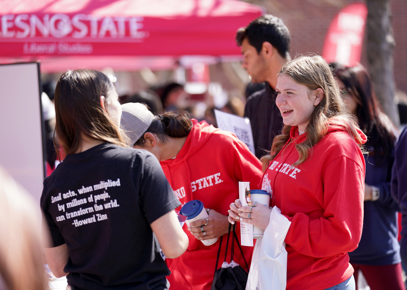 student smiling at booth on preview day