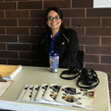 Person Smiling at Camera and Sitting at Table