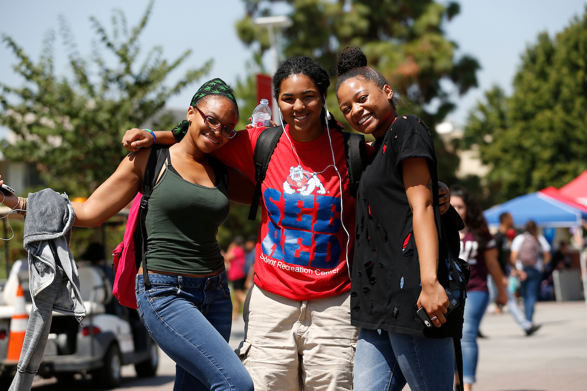 three students smiling at a event