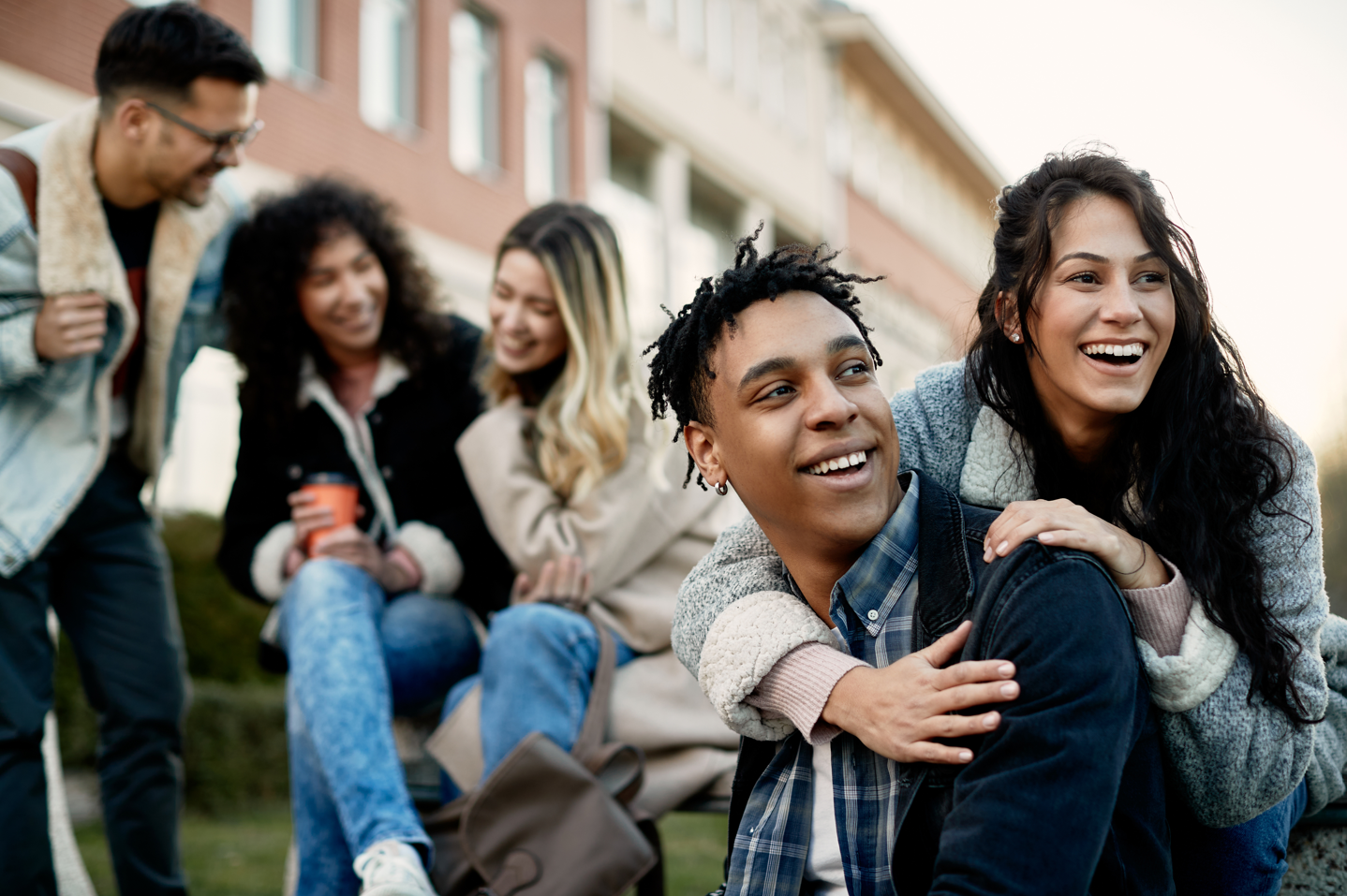 a group of students hanging out and smiling on campus