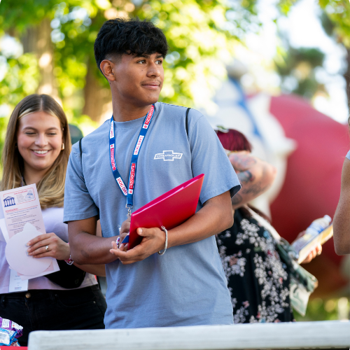 students in a crowd, bulldog inflatable in background