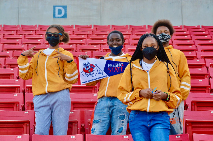 four students in the baseball stands