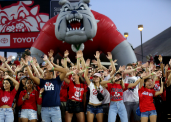 Group of students waving hands at stadium 