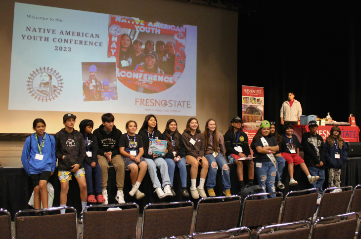 group of school students taking a picture in front of the stage