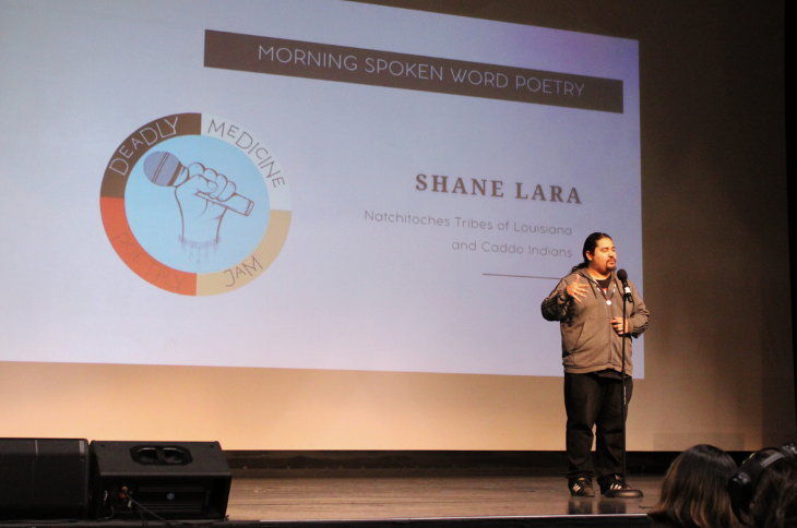 student on stage sharing poetry