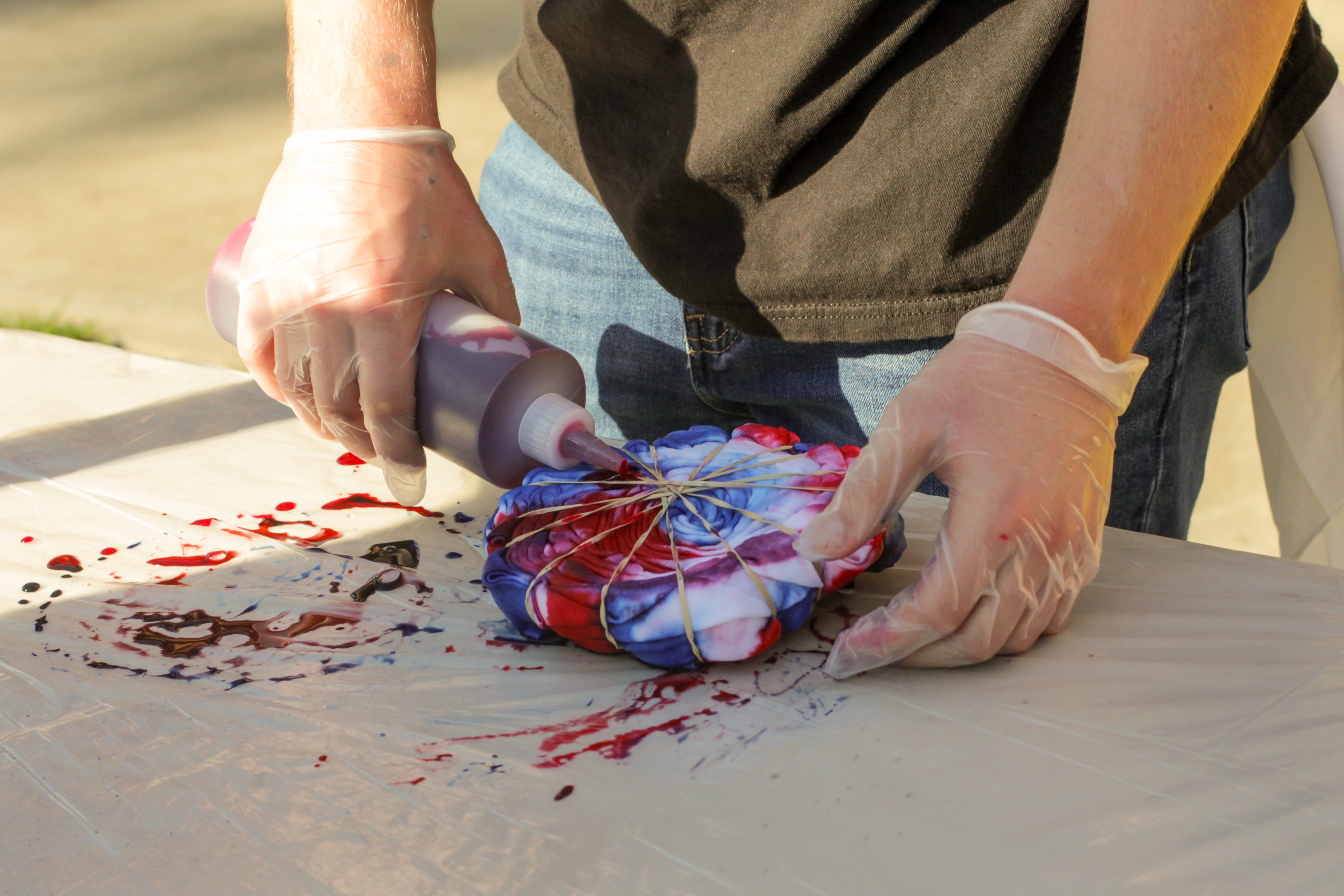 Student tie-dyeing a Fresno State shirt
