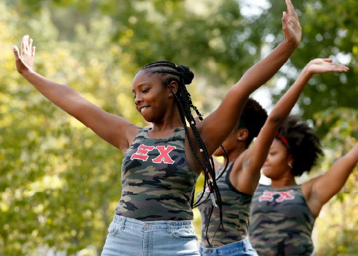 Three Sorority Members with their Arms in the Air