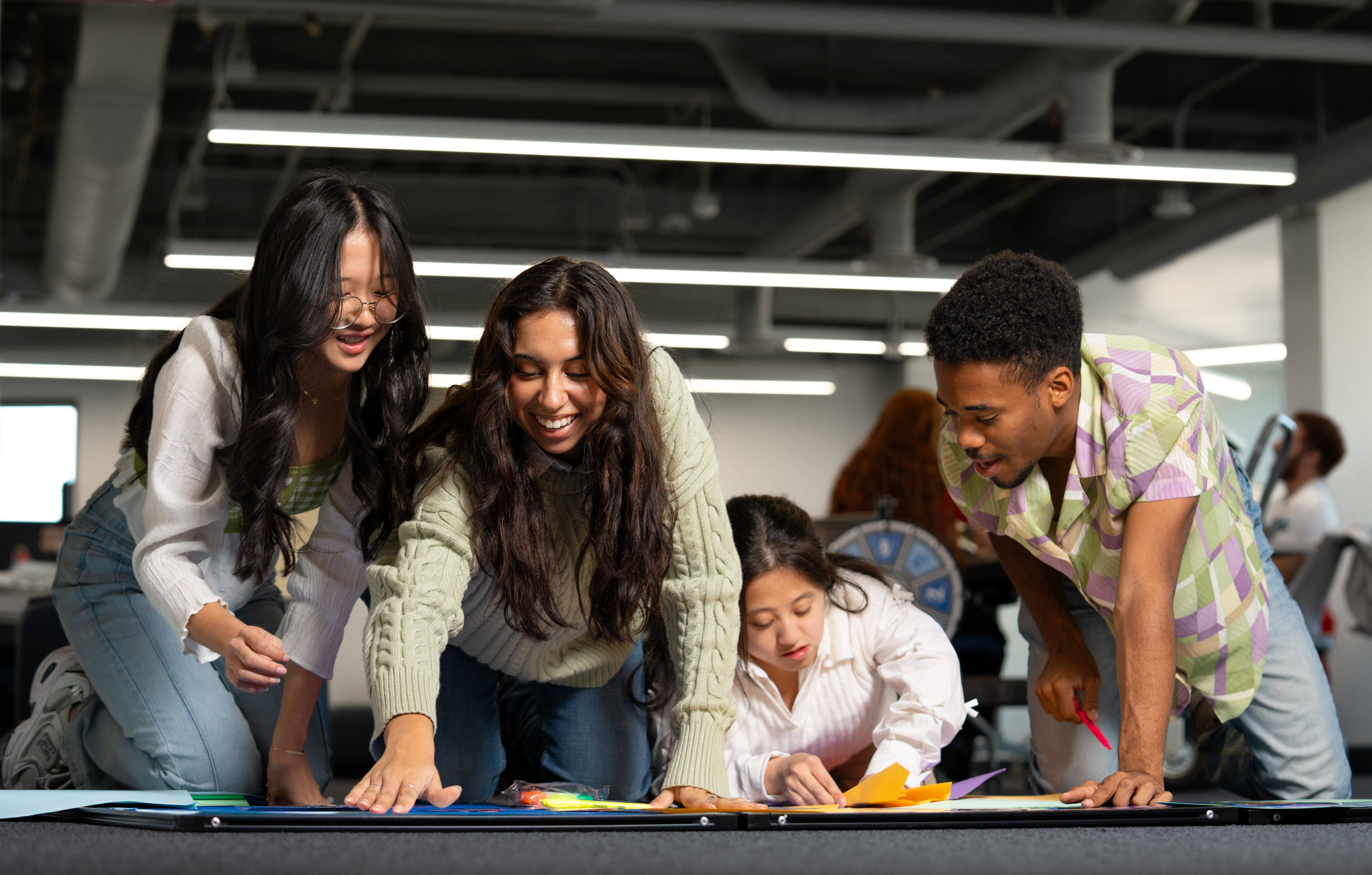 Four students on the ground, making something for an event