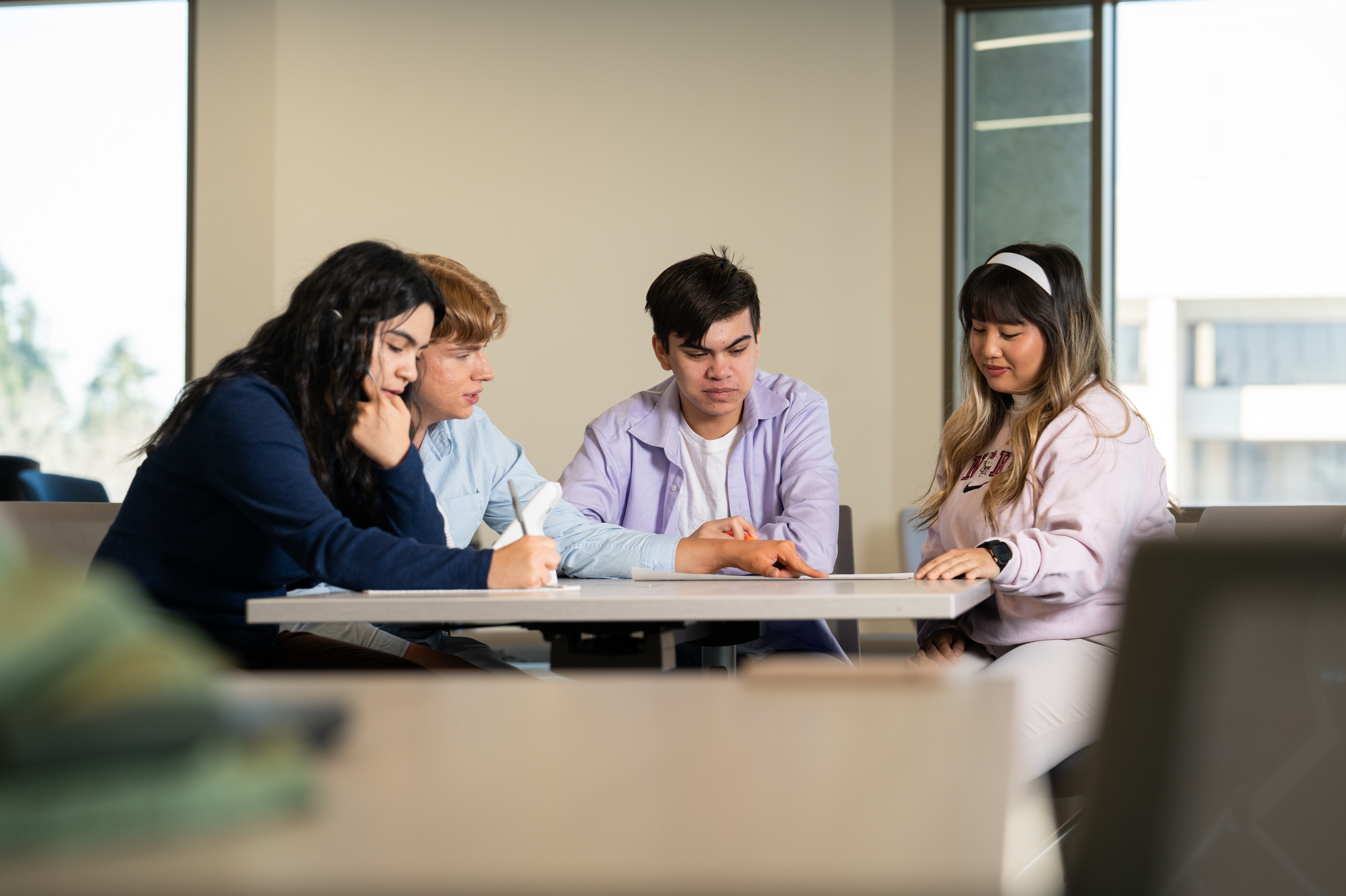 Four members of the Vintage Days committee chatting at a meeting table