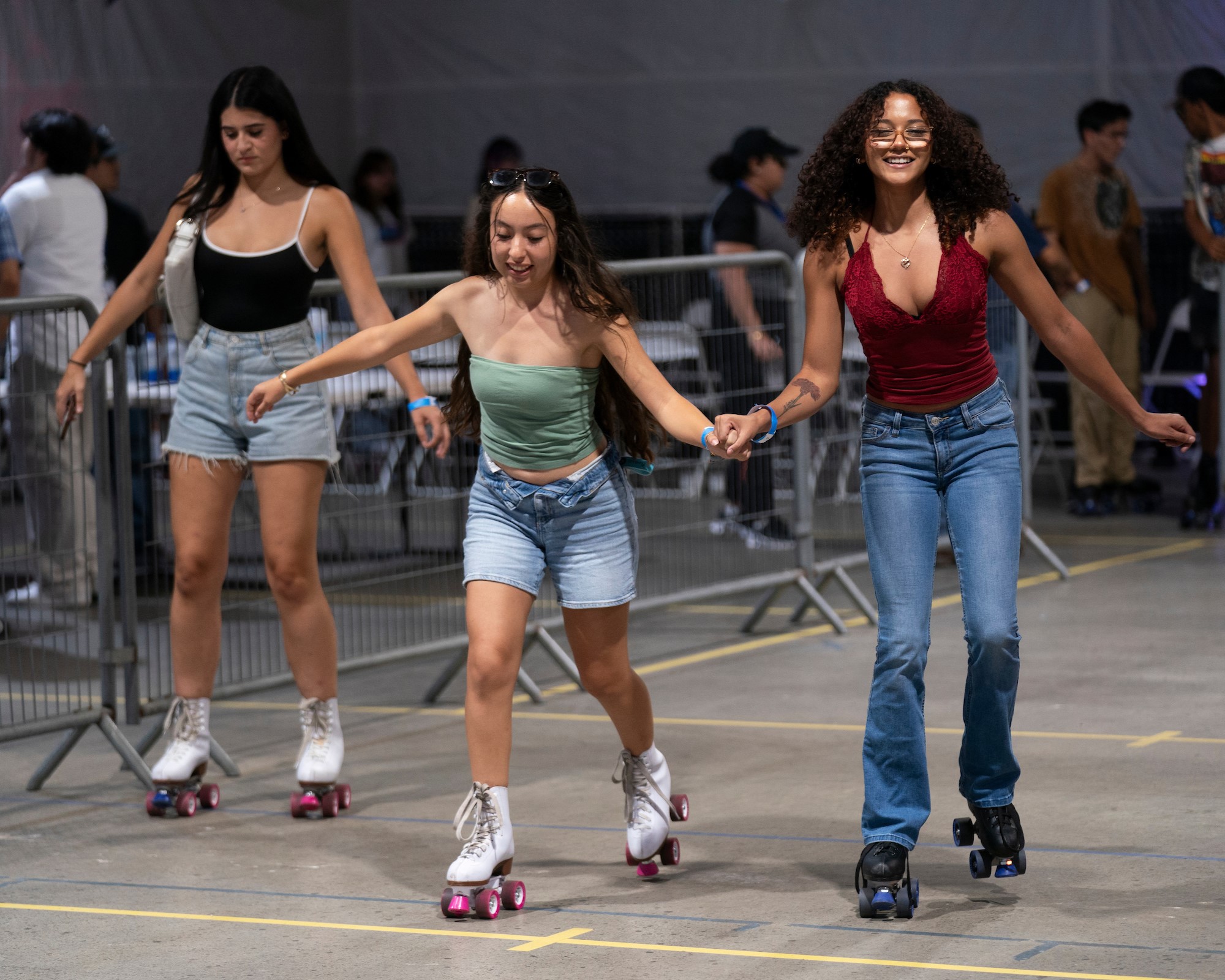 Three students rollerskate at Campus Pointe night