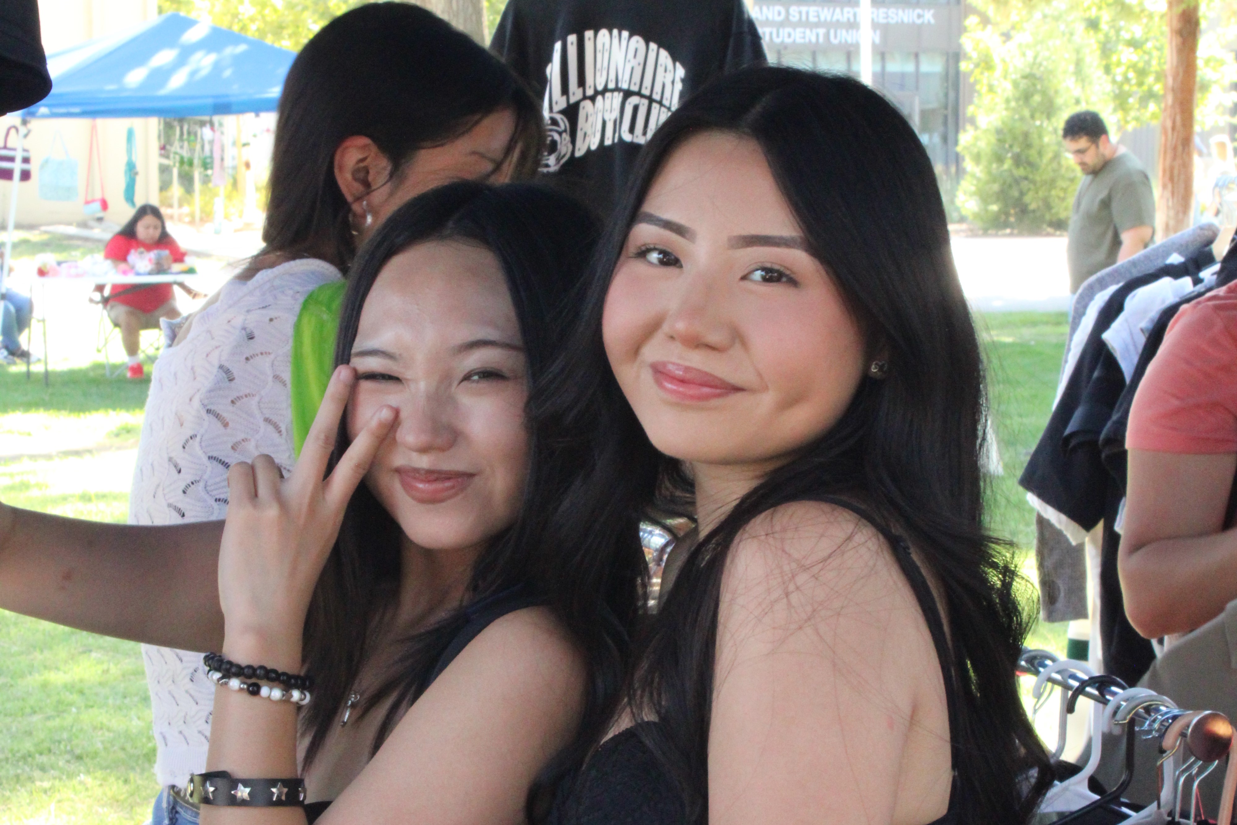 Two girls selling merchandise pose for the camera