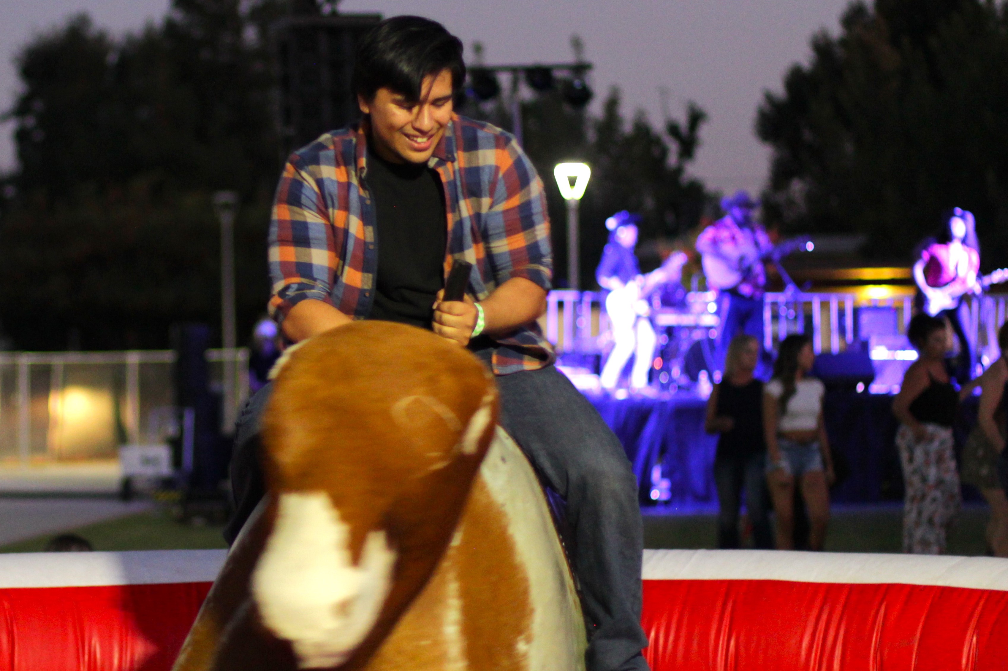 A student enjoys the mechanical bull at a night event
