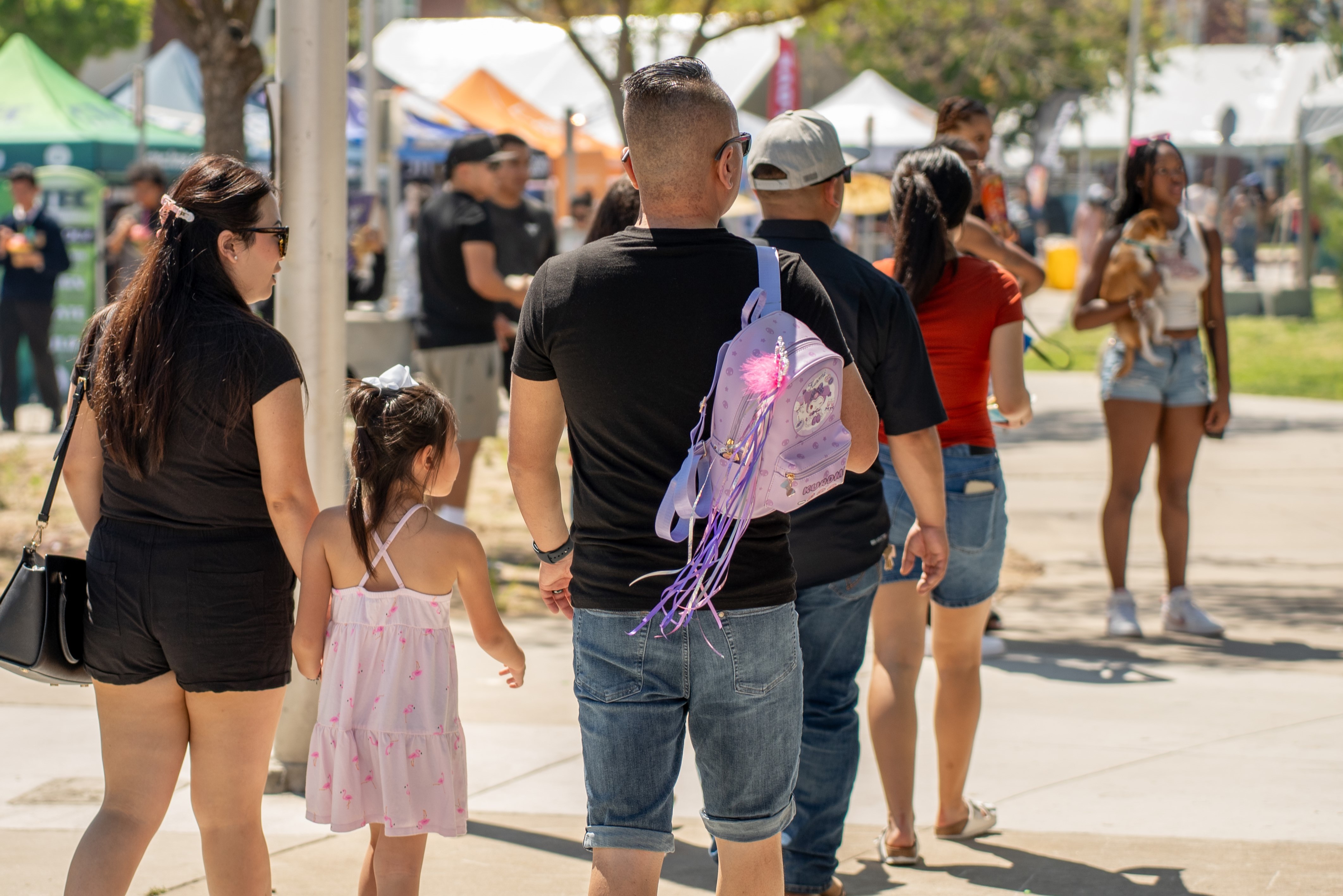 A family walks around, viewing Vintage Days' festivities