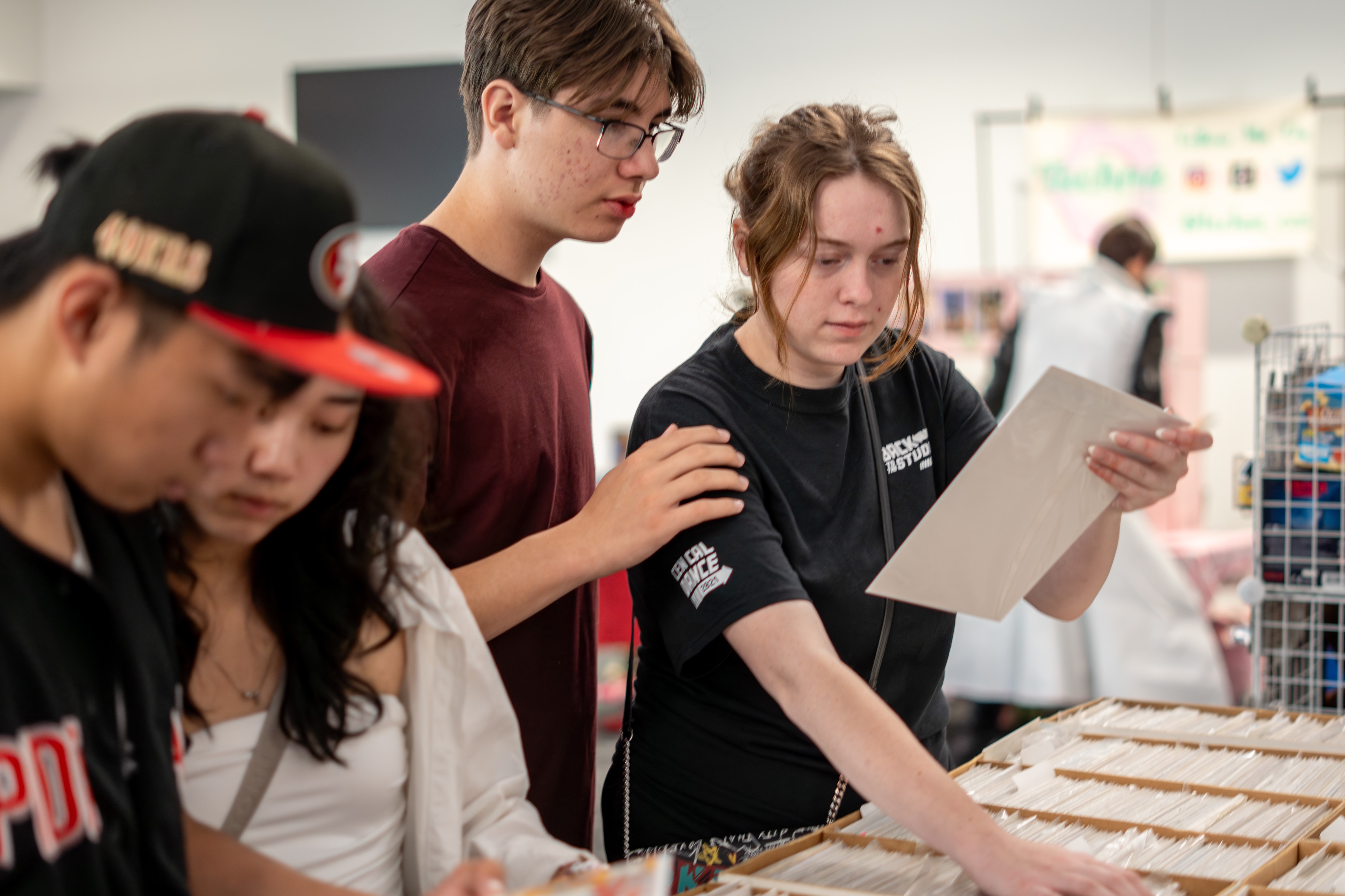 Students browsing boxes of comics intently