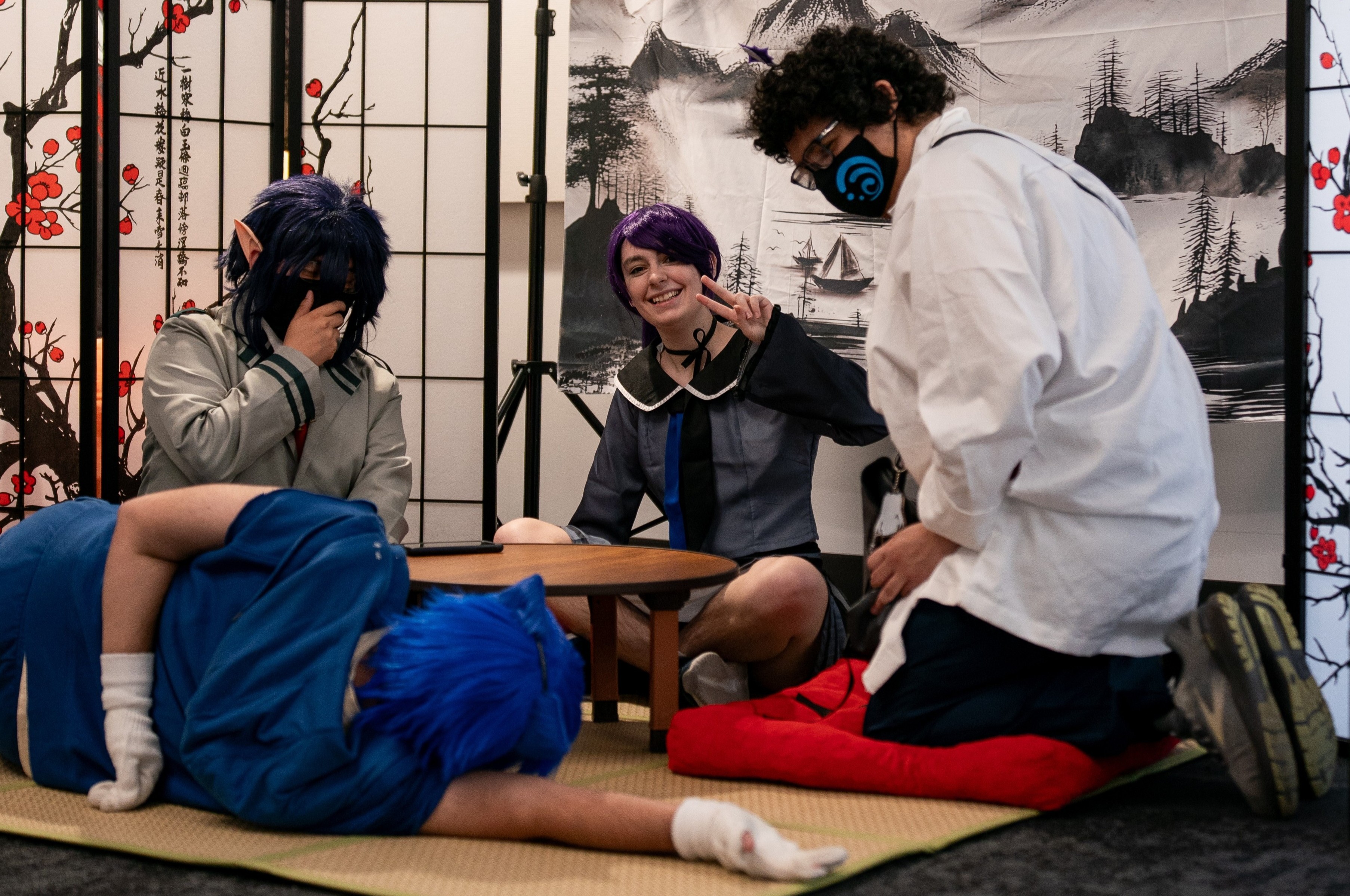 Excited cosplayers posing at the ornamental Japanese tea set photo-op