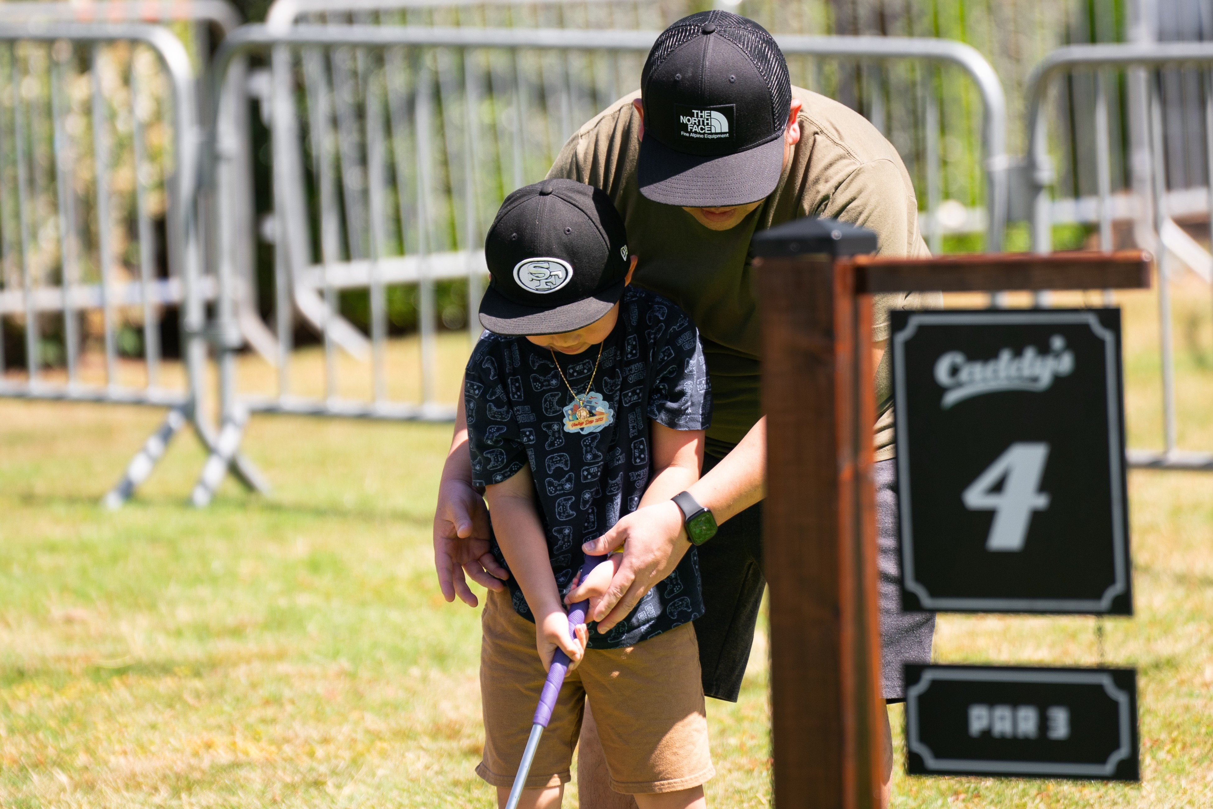A boy and his dad golfing on the mini-golf course