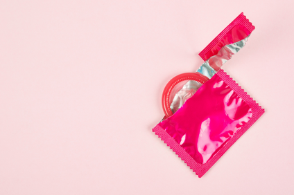 an pink, torn open condom wrapper