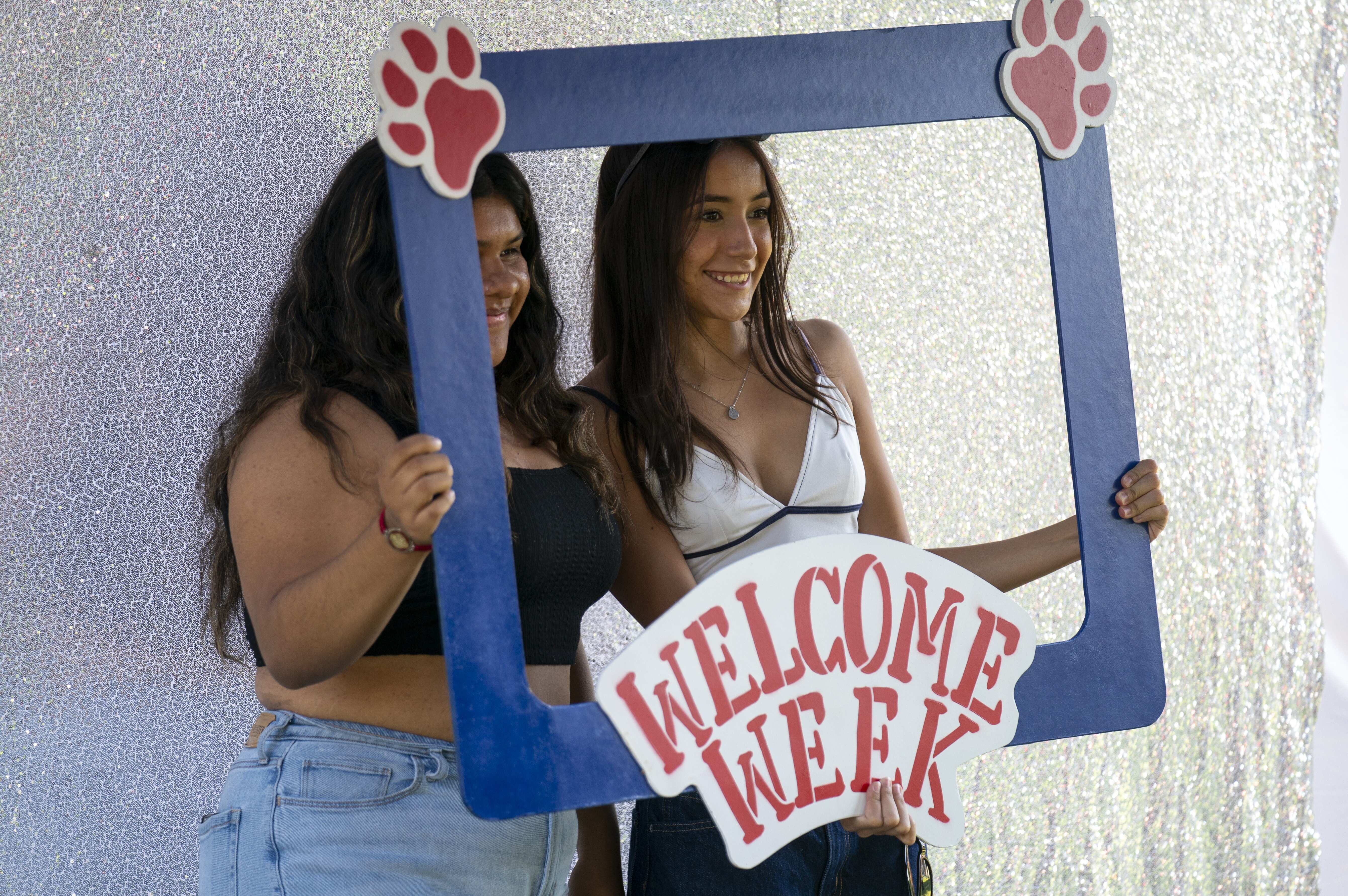 Students pose for the photobooth with a Welcome Week cut-out