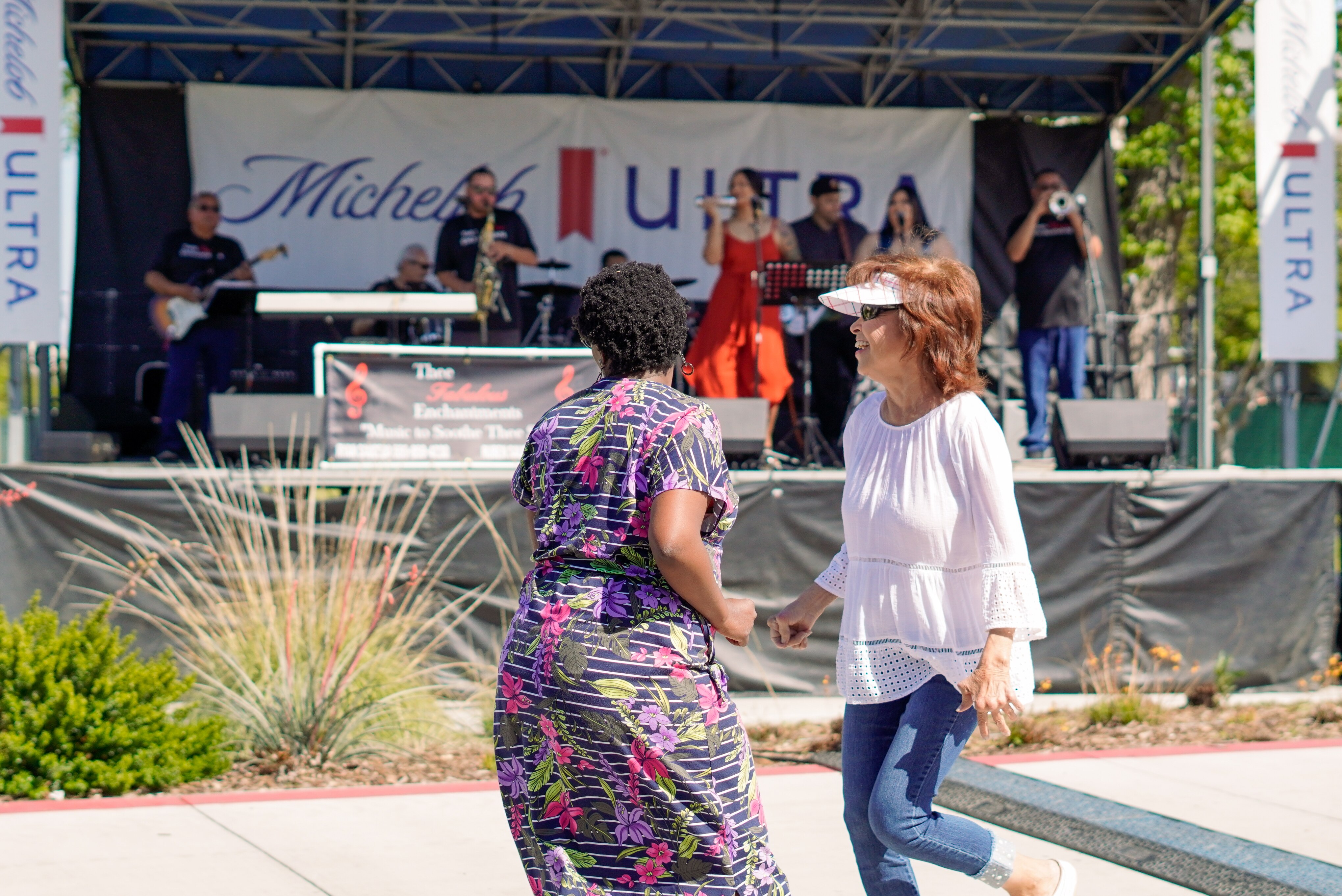Two women dance in front of the performance stage to live music